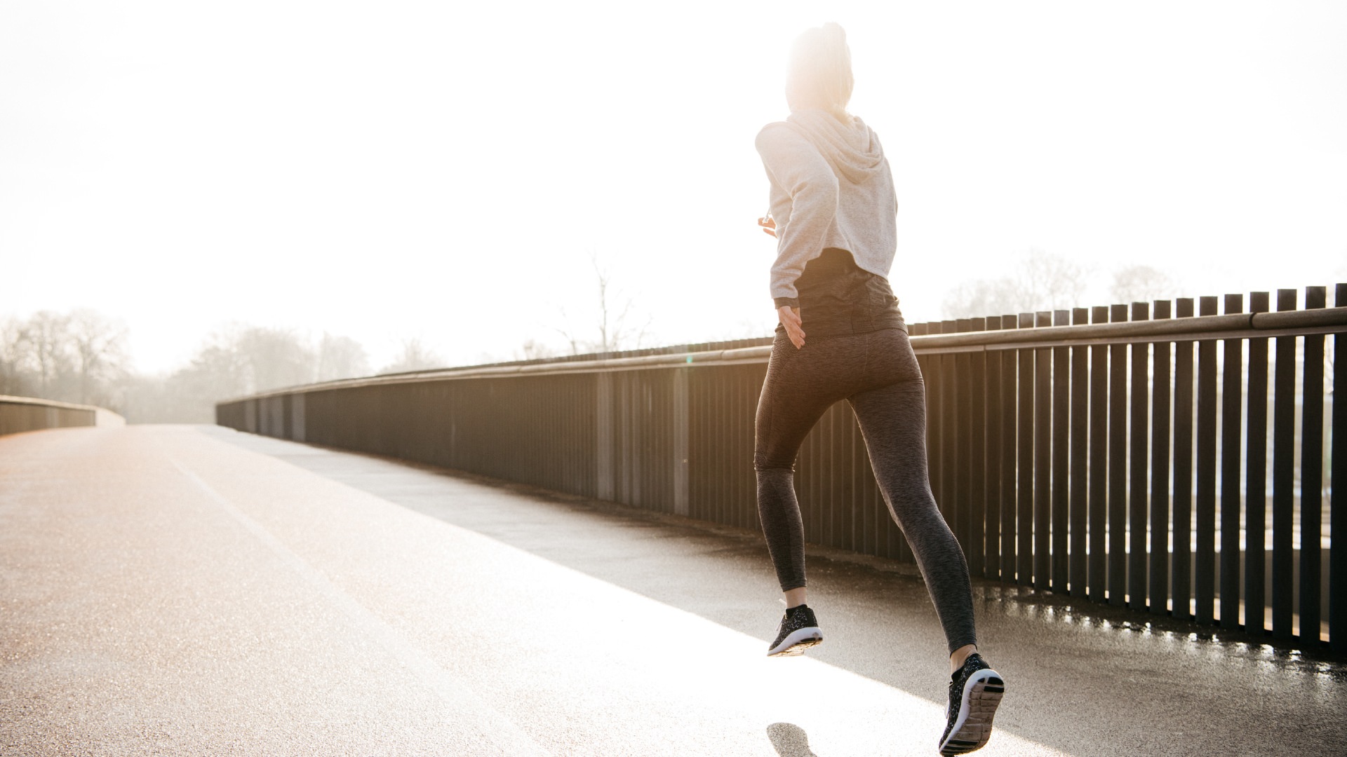 Woman running across a bridge